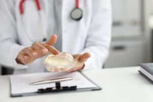 Silicone vs. Saline: Choosing the Right Type of Breast Implant for You A doctor holding a silicone breast implant in their hand