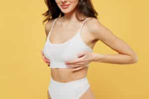 Woman in white bra has symmetrical breasts after cosmetic surgery in Chicago.