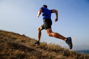 Man running on a mountain looks to strengthen his calf muscles for improved leg contours